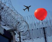 Stacheldraht und Luftballon als gegensätzliche und doch nebeneinander bestehende Symbole für Freiheitsent- und Familienbezug