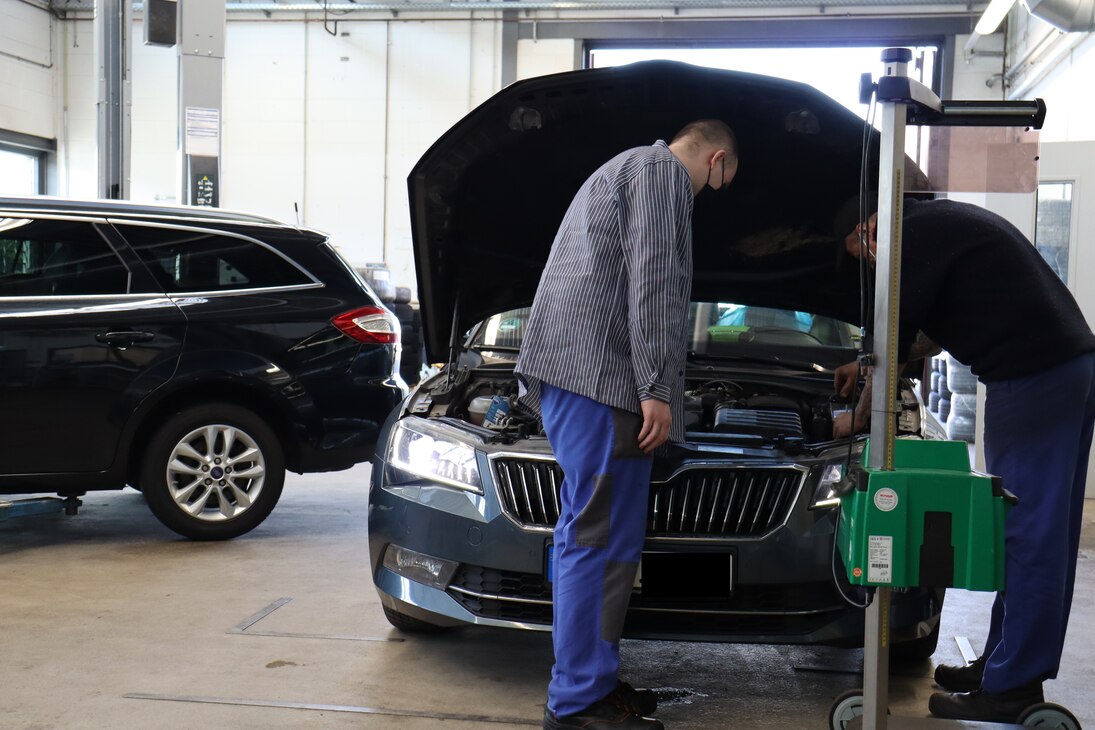 Gefangene der Anstalt bei der Arbeit in der Kfz-Werkstatt