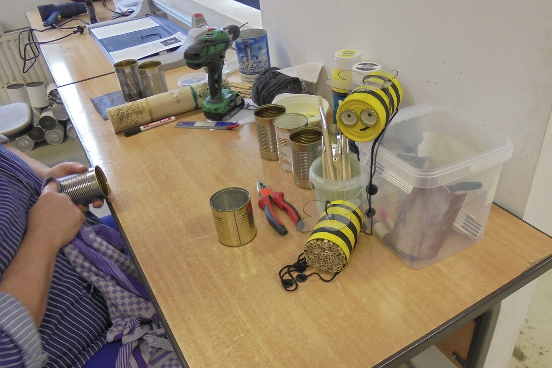 Das Bild zeigt die Herstellung eines Insektenhotel aus leeren Konservendosen