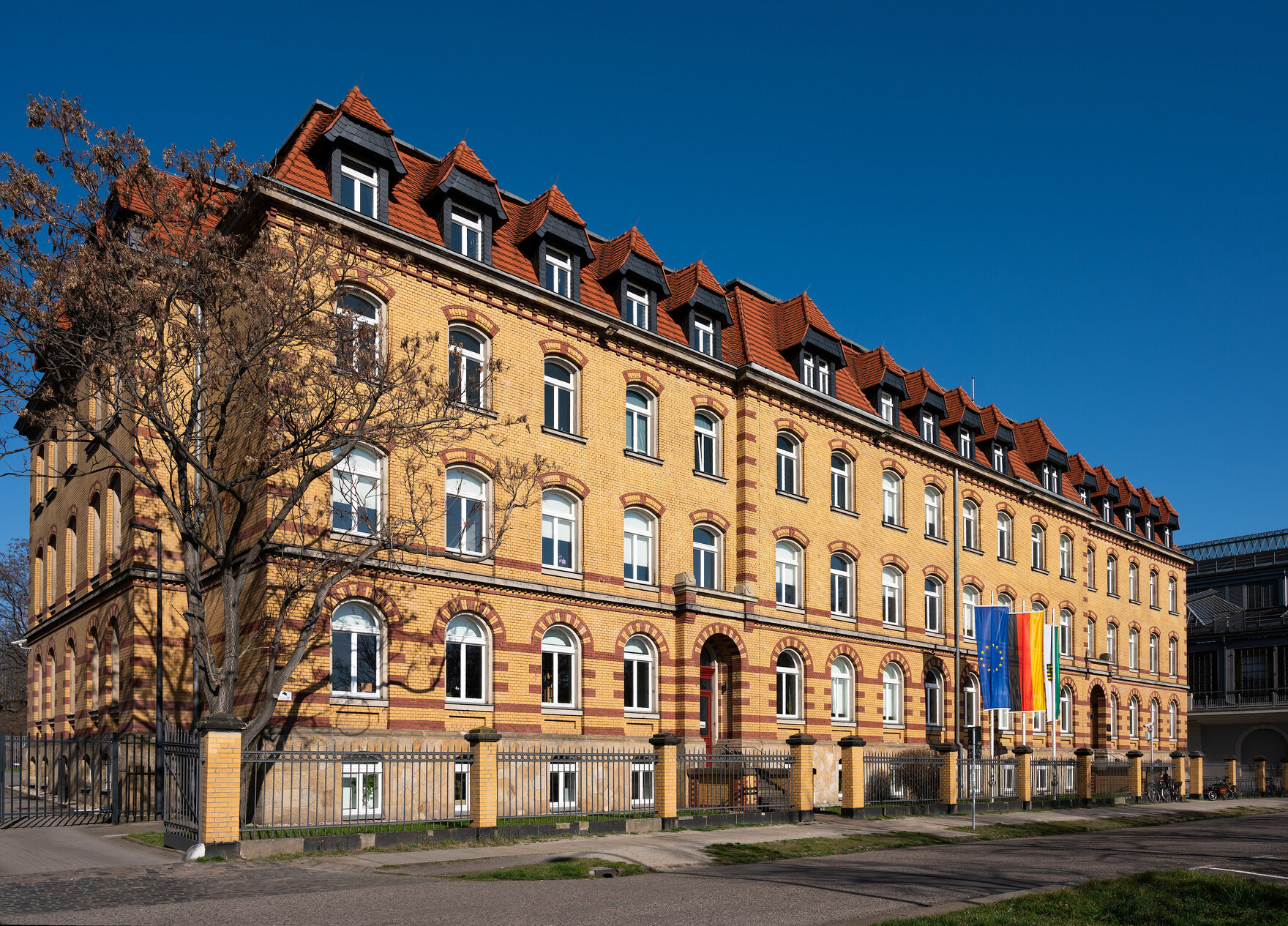 Großes gelbes Backsteinhaus in der Sonne.