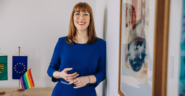 Staatsministerin Meier lehnt in ihrem Bür an einer Wand.